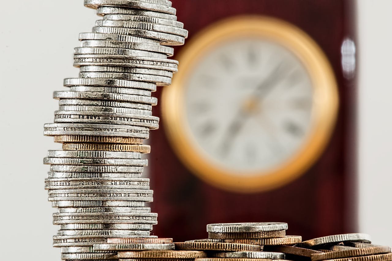 our-services-2 A close-up image of stacked coins with a blurred clock, symbolizing time and money relationship.