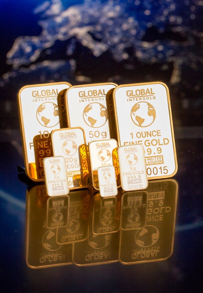 gallery-5 Collection of gold bars featuring a global map and weight inscriptions.