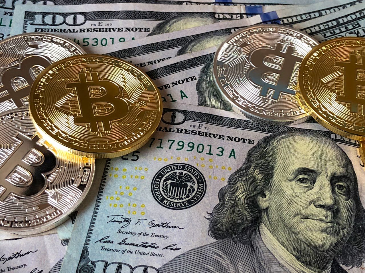 about-img A close-up photo depicting Bitcoin coins on top of US dollar bills, symbolizing finance and cryptocurrency.