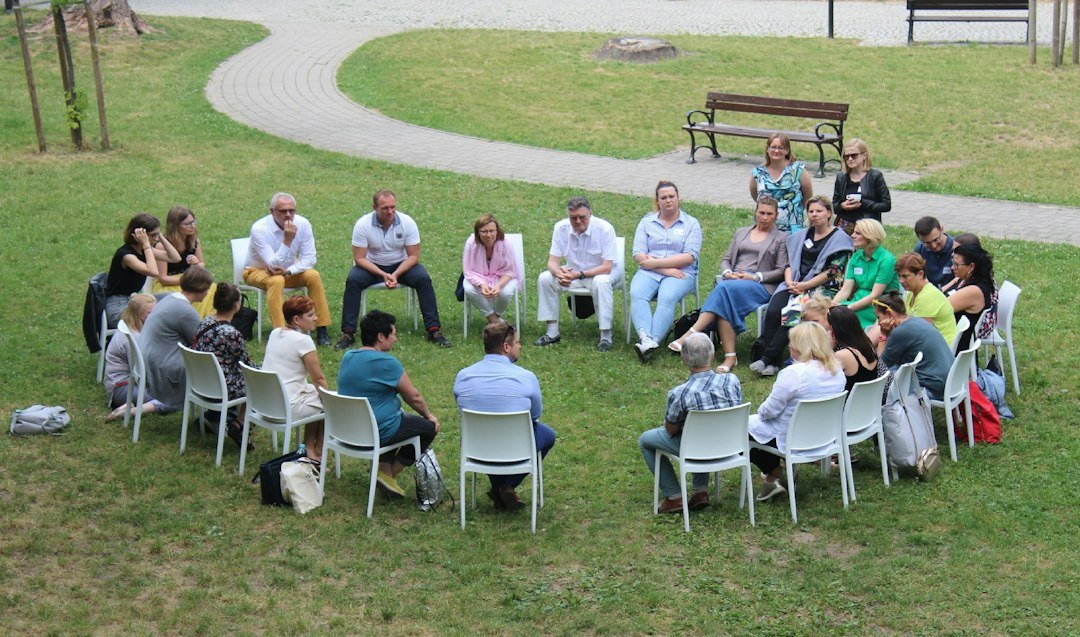 People seated in a circle outdoors during a community discussion
