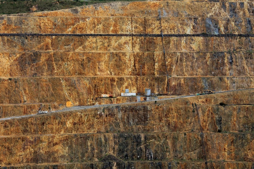 A winding haul road through a large open-pit mining landscape illustrating ongoing mine operating costs