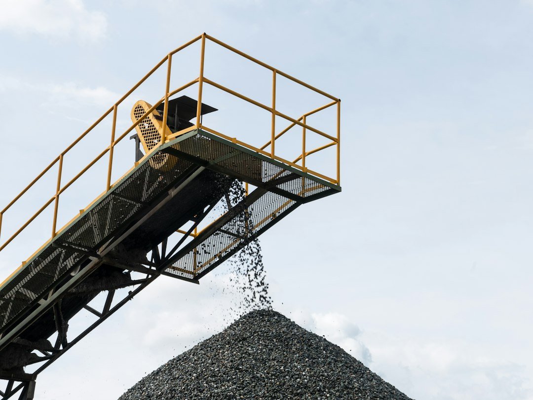 Loader working beside a large mineral stockpile