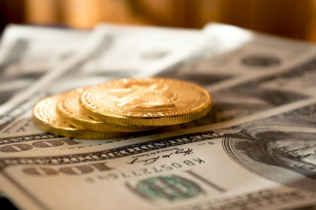 Gold-colored coins resting on United States dollar banknotes