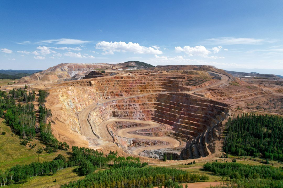 Aerial view of a large open-pit mine surrounded by forest